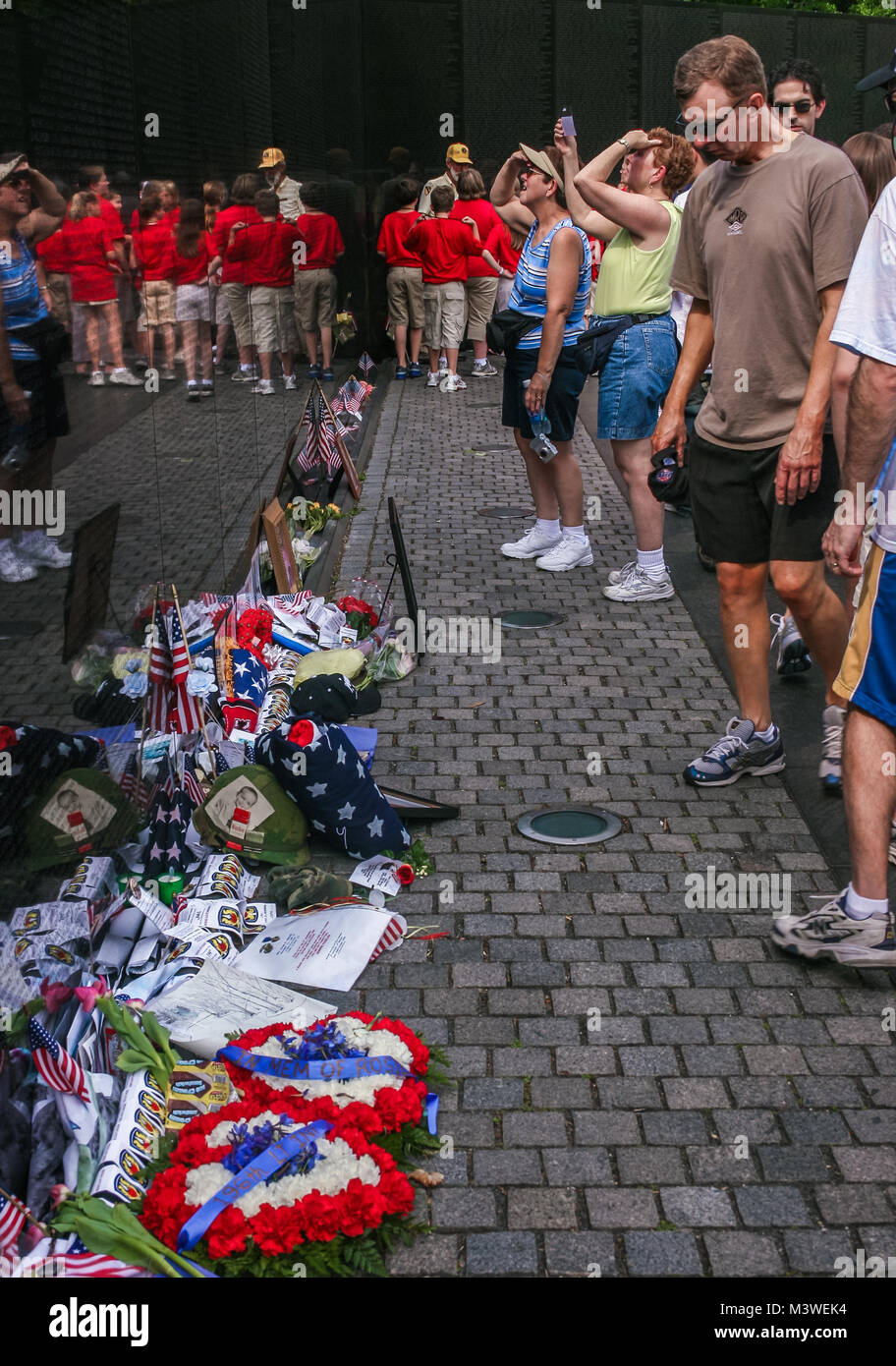 View of the Vietnam Wall Memorial Wall and its visitors, letters, flowers and gifts laying by the Wall Stock Photo