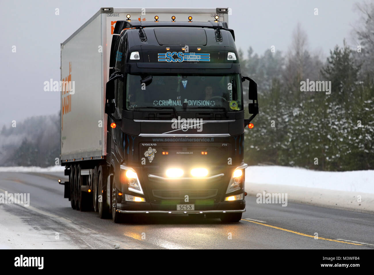 RAASEPORI, FINLAND - FEBRUARY 9, 2018: Beautifully customized black Volvo FH truck of SCS for Posti Group transports lights up the wintery highway in  Stock Photo