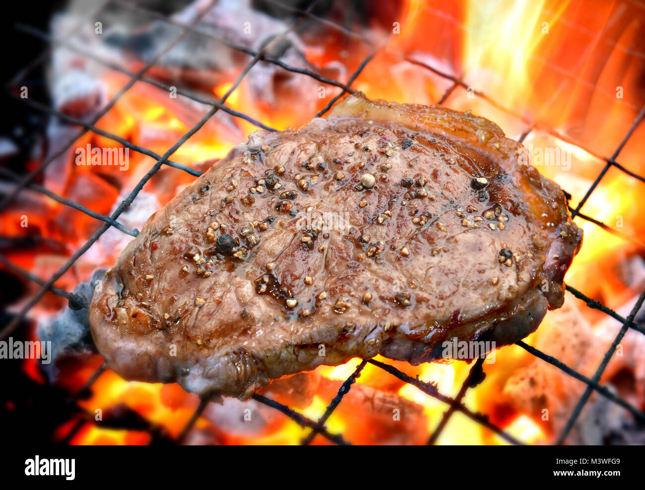 grilling pepper steaks on flaming in outdoor lighting Stock Photo Alamy