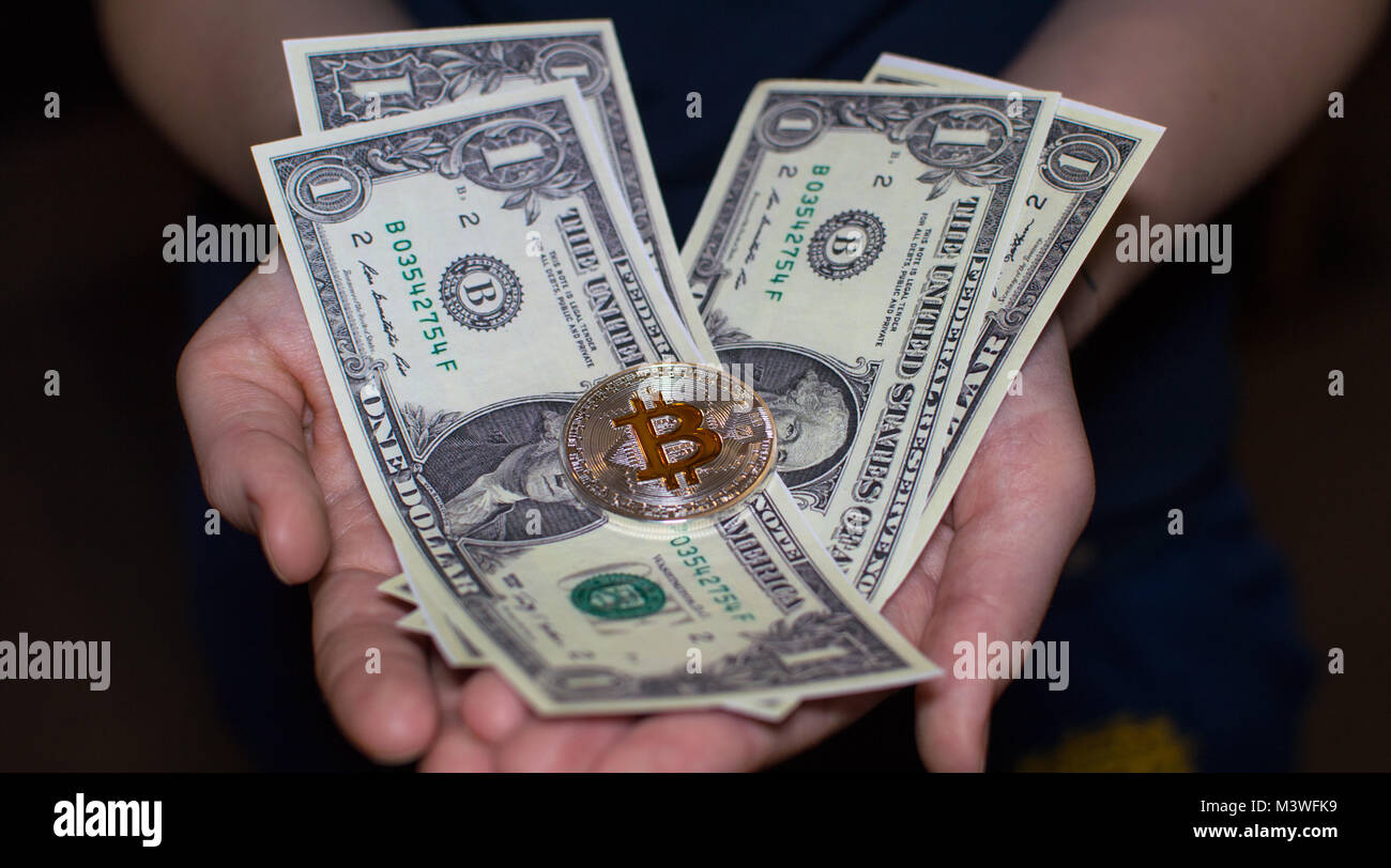 Bitcoin silver gold coin and dollar in hands. Stock Photo