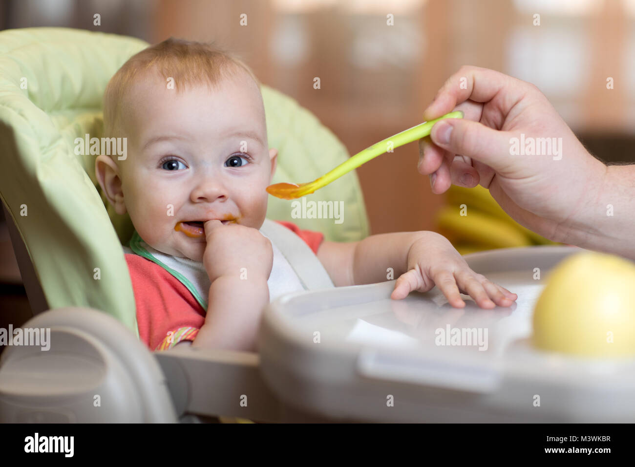 father feeding baby with spoon Stock Photo Alamy
