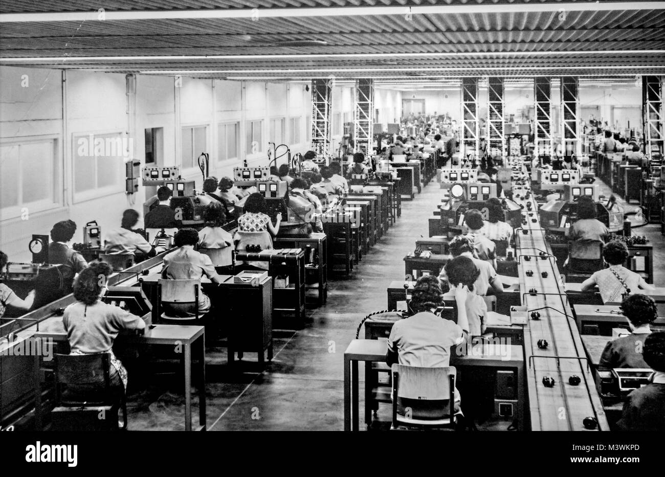 Old black and white archival photograph showing female workers manufacturing small electric motors in factory in the 1950s Stock Photo