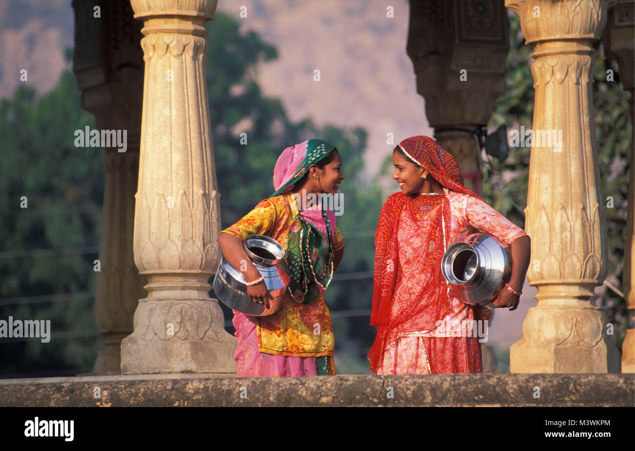 India. Rajasthan. Samode near Jaipur. Two women with water cans, carrying water. Stock Photo