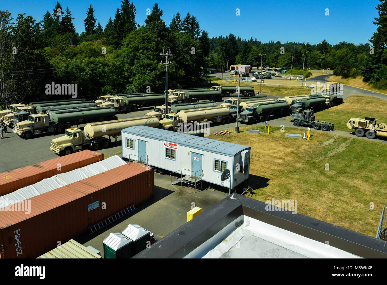 170718-N-SH284-228 MANCHESTER, Wash. (July 18, 2017) United States Army 475th Quartermaster Group fuel trucks are staged in an empty lot at Naval Supply Systems Command Fleet Logistics Center (NAVSUP FLC) Puget Sound’s Manchester Fuel Depot during the 2017 Quartermaster Liquid Logistics Exercise (QLLEX). QLLEX is an annual exercise for Army Reserve units to train for their wartime mission of providing petroleum and water to units throughout the continental United States. This year’s exercise had convoys of Army trucks based out of Joint Base Lewis-McCord (JBLM) transporting fuel provided by NA Stock Photo