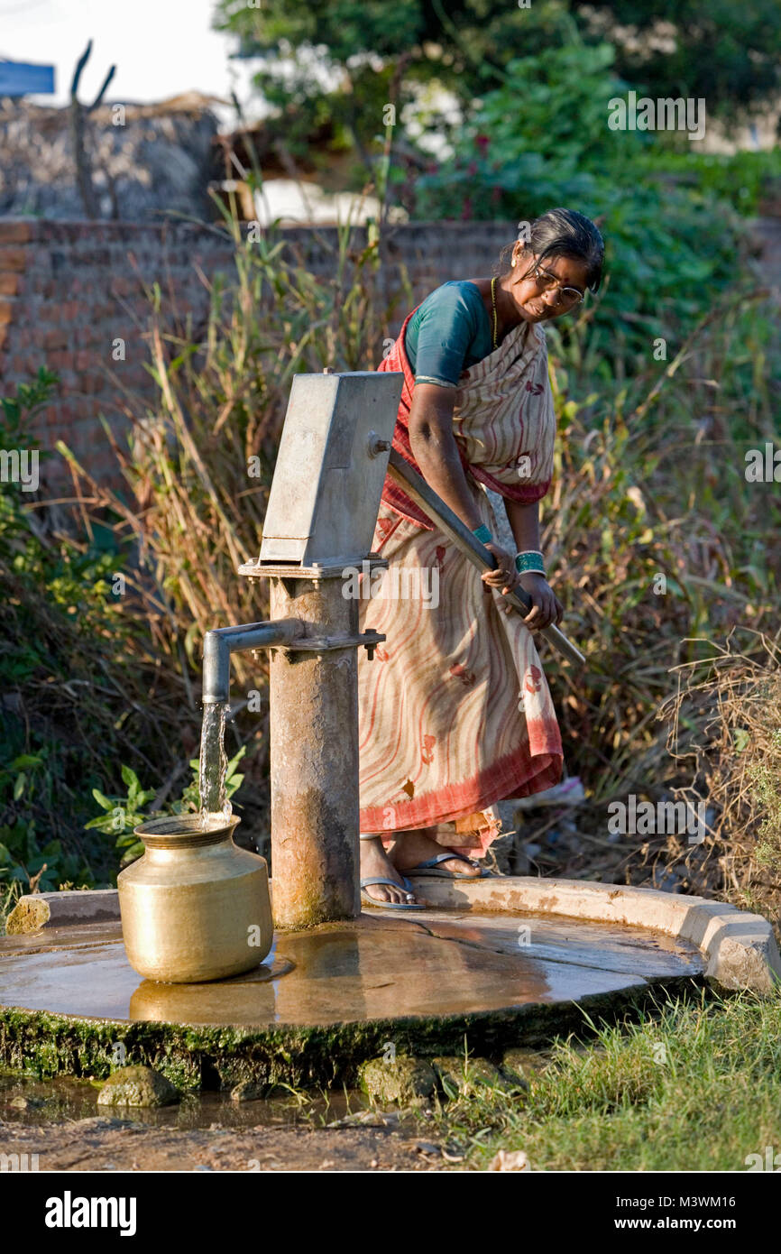 India, near Hyderabad. Countryside near Nalgonda. Woman pumping water from outdoor well. Stock Photo
