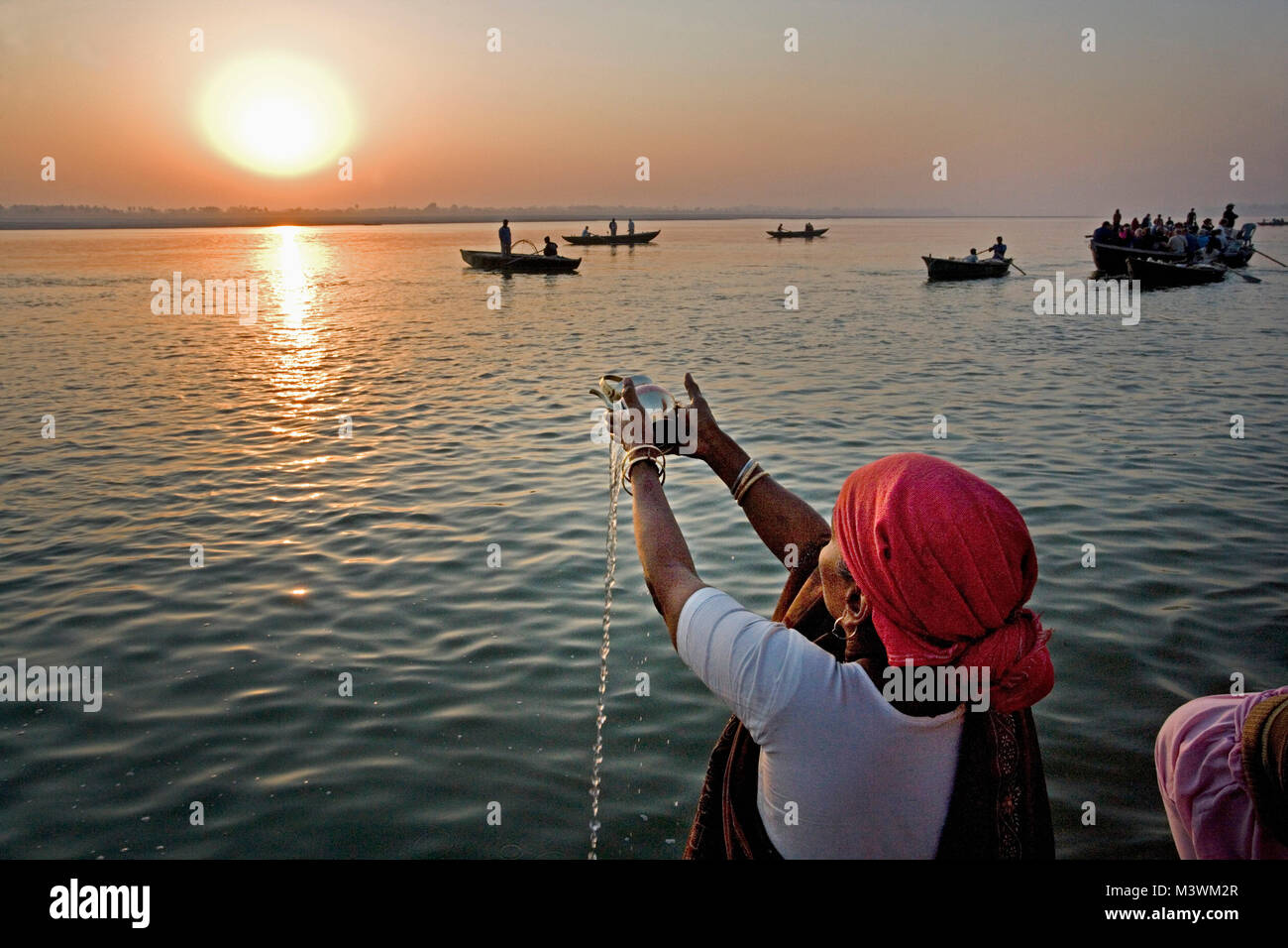India. Varanasi (Benares). The ghats. Hindu pilgrims worshipping and to wash away their sins in the Ganges River. Stock Photo