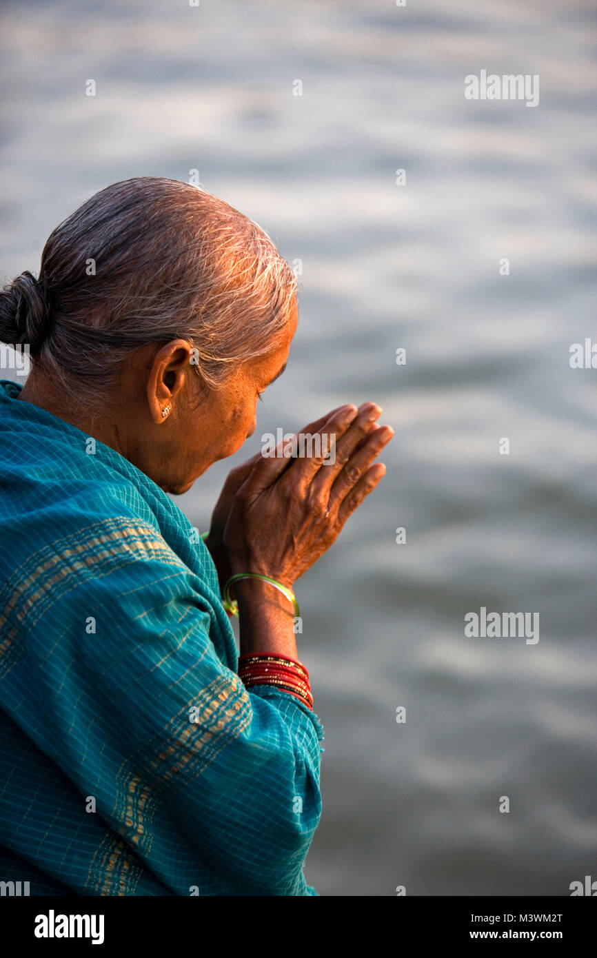 India. Varanasi (Benares). The ghats. Hindu pilgrims worshipping and to wash away their sins in the Ganges River. Stock Photo