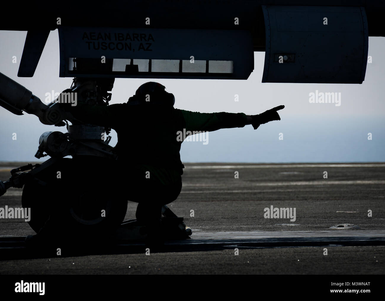 ARABIAN GULF (Aug. 8, 2017) U.S. Navy Aviation Boatswain's Mate (Equipment) Airman Michael Kirby, from Smithsburg, Md., does final checks on an aircraft during flight operations aboard the aircraft carrier USS Nimitz (CVN 68), Aug. 8, 2017, in the Arabian Gulf. Nimitz is deployed in the U.S. 5th Fleet area of operations in support of Operation Inherent Resolve. While in this region, the ship and strike group are conducting maritime security operations to reassure allies and partners, preserve freedom of navigation, and maintain the free flow of commerce. (U.S. Navy photo by Mass Communication  Stock Photo