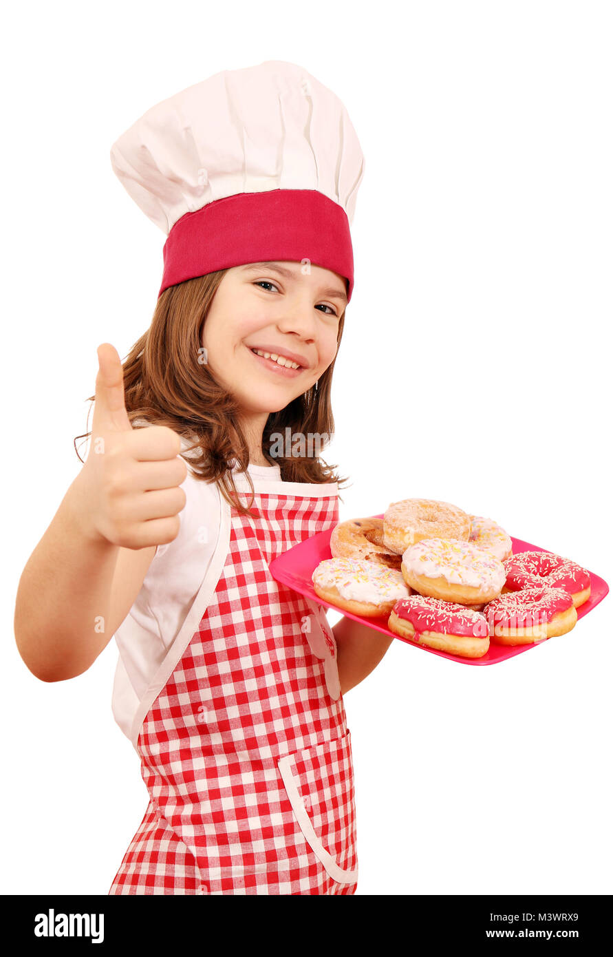 happy little girl cook with sweet donuts and thumb up Stock Photo - Alamy