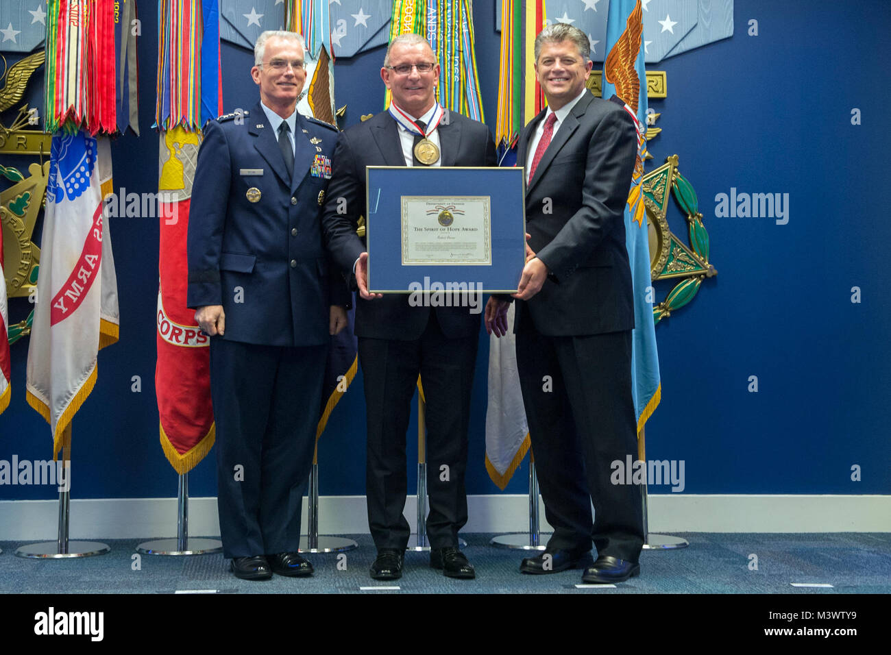 Robert Irvine, second from left, accepts The Spirit of Hope Award at the Pentagon in Arlington, Va. Oct. 26, 2017. The award is named after Bob Hope, the first honorary military veteran, and is presented to people whose patriotism and service reflect Hope’s. 171026-D-DB155-002 by DoD News Photos Stock Photo