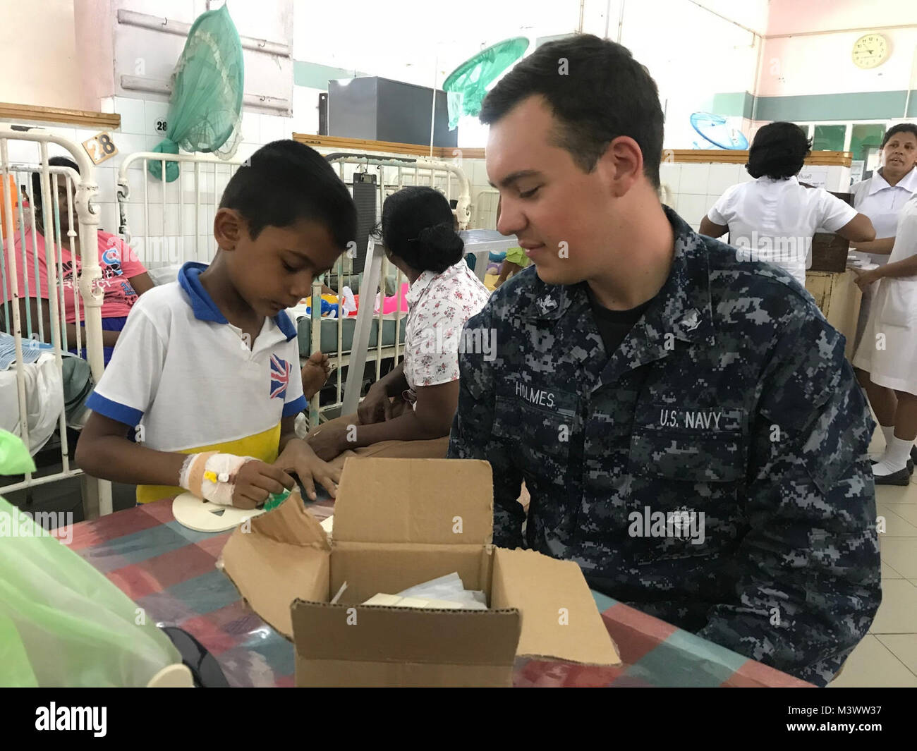 171029-N-OU681-0004 COLOMBO, Sri Lanka (Oct. 29, 2017) Information Systems Technician 3rd Class Joe Holmes, assigned to Ticonderoga-class guided-missile cruiser USS Princeton (CG 59), does crafts with a boy at Lady Ridgeway Hospital in Colombo, Sri Lanka, during a volunteer event with Nimitz Carrier Strike Group (CSG). Nimitz CSG is on a regularly scheduled deployment in the 7th Fleet area of responsibility in support of maritime security operations and theater security cooperation efforts. (U.S. Navy photo by Lt. j.g. Michelle Tucker/Released) 171029-N-OU681-0004 by Naval Base Kitsap (NBK) Stock Photo