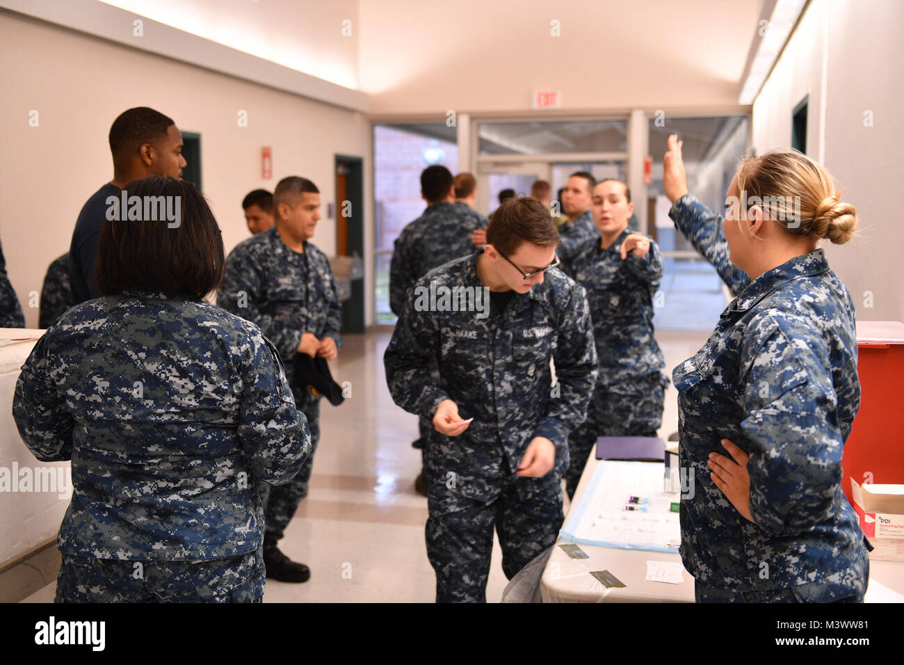 20171101-N-JT254-018 SILVERDALE, Wash. (November 01, 2017) Hospital Corpsman assigned to Naval Hospital Bremerton, direct Sailors to flu vaccine stations.  The influenza, or “flu”, has the potential to adversely impact Navy force readiness and mission execution, and vaccination is mandatory for DoD uniformed personnel. (U.S. Navy photo by Mass Communication Specialist Seaman Christopher Jahnke) 171101-N-JT254-018 by Naval Base Kitsap (NBK) Stock Photo
