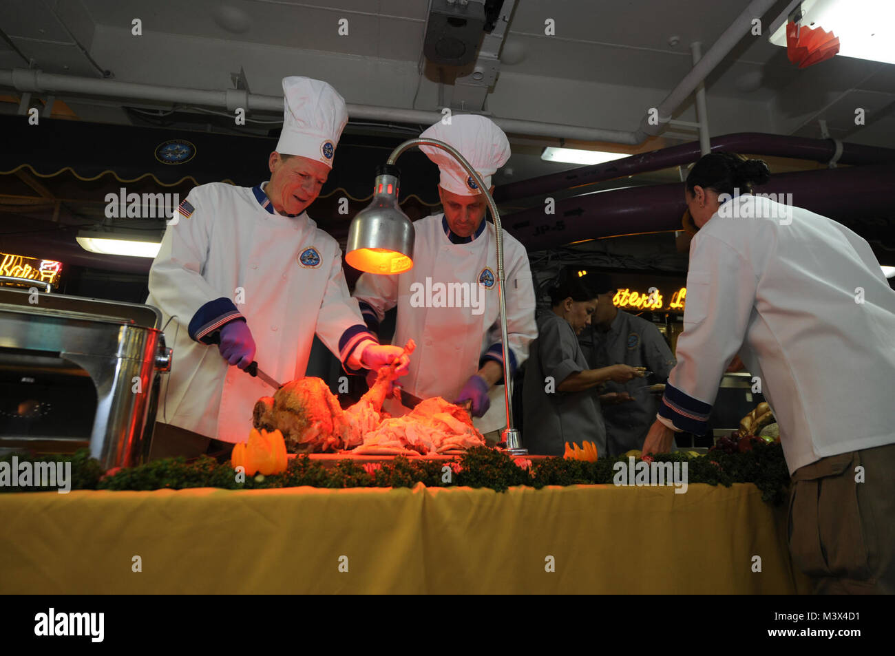 PACIFIC OCEAN (Nov. 28, 2013) – Rear Adm. Michael S. White, commander, Carrier Strike Group 11, left, and Capt. J.J. Cummings, executive officer of the aircraft carrier USS Nimitz (CVN 68), carve a turkey during a Thanksgiving meal served aboard Nimitz. Nimitz is deployed to the U.S. 7th Fleet area of responsibility supporting security and stability in the Indo-Asia-Pacific region. (U.S. Navy photo by Mass Communication Specialist Seaman Apprentice Kelly M. Agee/ Released) 131128-N-AZ866-227.JPG by USS NIMITZ (CVN 68) Stock Photo