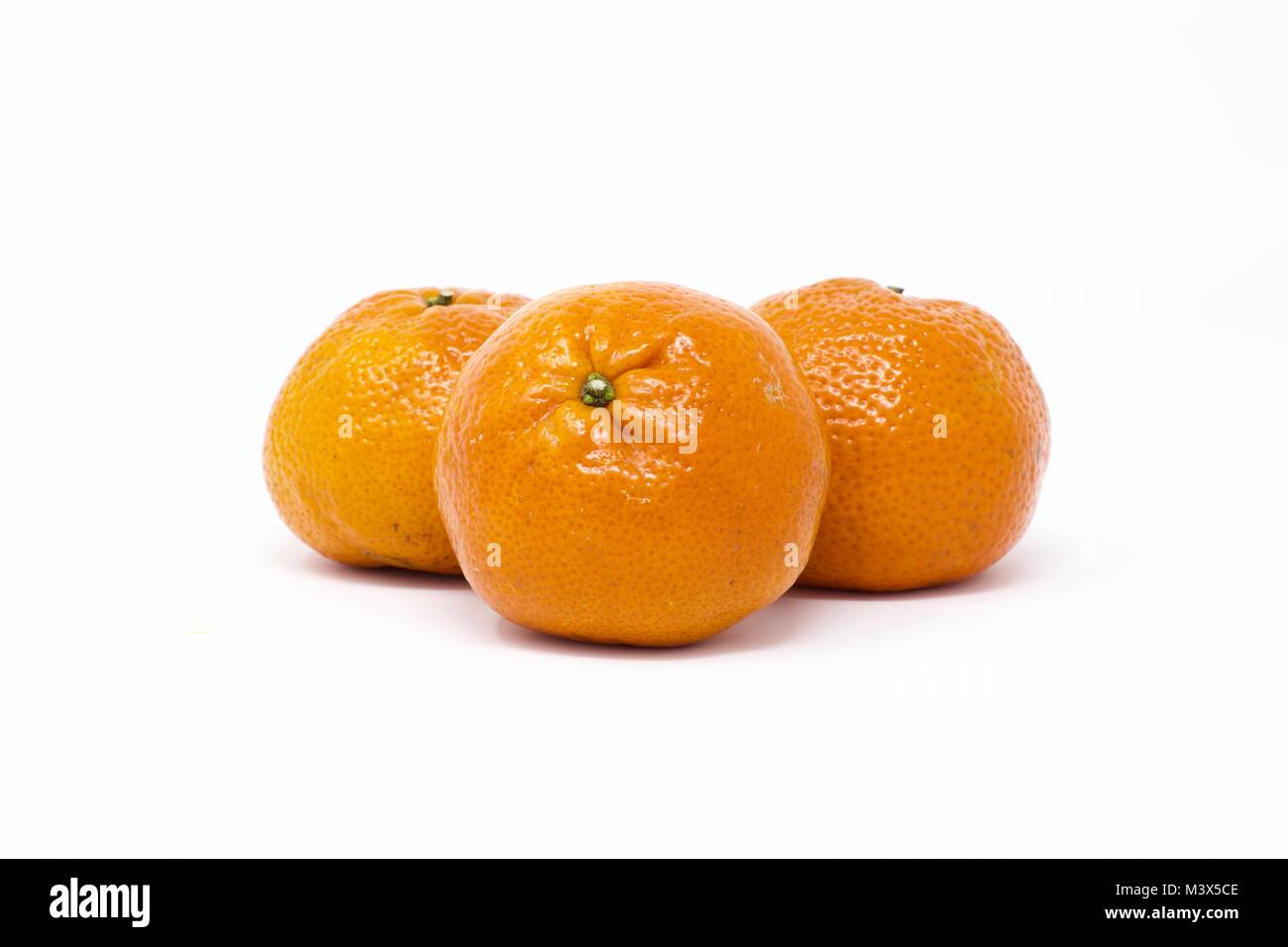 Three clementines ( citrus clementine) on a white background Stock