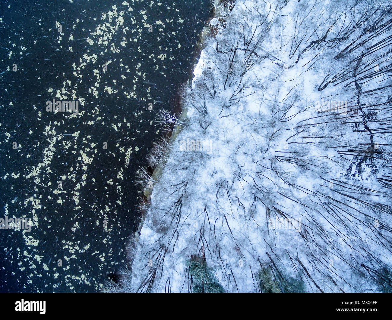 Aerial top view of winter forest and ice drift on the river Stock Photo