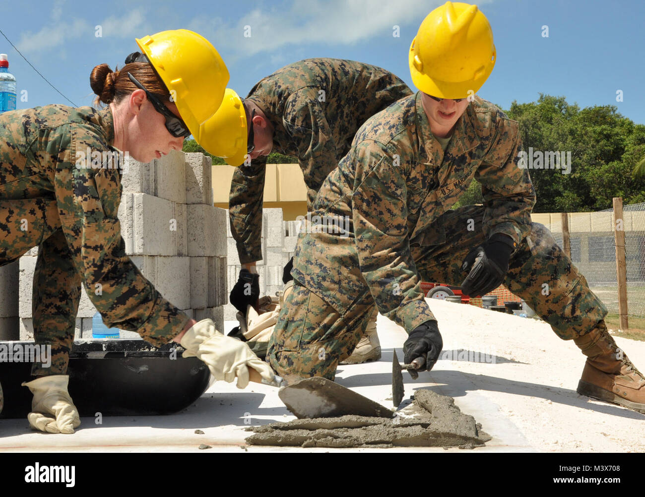 U.S. Marine Corps Cpl. Melissa Baker, left, and Lance Cpl. David Cafarelli, right, Marine Wing Support Squadron 472, prepare a corner of the Edward P. Yorke school construction site to lay block March 31, 2014, in Belize City, Belize. Marines from MWSS-472 will work side by side with engineers from the Belizean Defence Force to provide an additional classroom to the Yorke school. The construction is part of New Horizons Belize 2014, an exercise to build partnerships and learn from one another in construction and medical realms. (U.S. Air Force photo by Tech. Sgt. Kali L. Gradishar/Released) U. Stock Photo