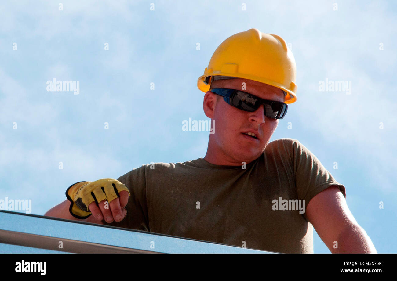 U.S. Marine Sgt. Kyle Dugas, Marine Wing Support Squadron, Det. 472, Bravo, out of Chicopee, Mass., assists with securing the roof at the Edward P. Yorke school addition construction site in Belize City, Belize, April 23, 2014. Dugas is deployed with a team of U.S. Air Force, Marine and Army engineers in support of the U.S. Southern Command-sponsored New Horizons exercise. The exercise gives U.S. military members the opportunity to deploy, operate, and re-deploy while including the added benefit of working with and learning from our international partners. (U.S. Air Force photo by Tech. Sgt. K Stock Photo