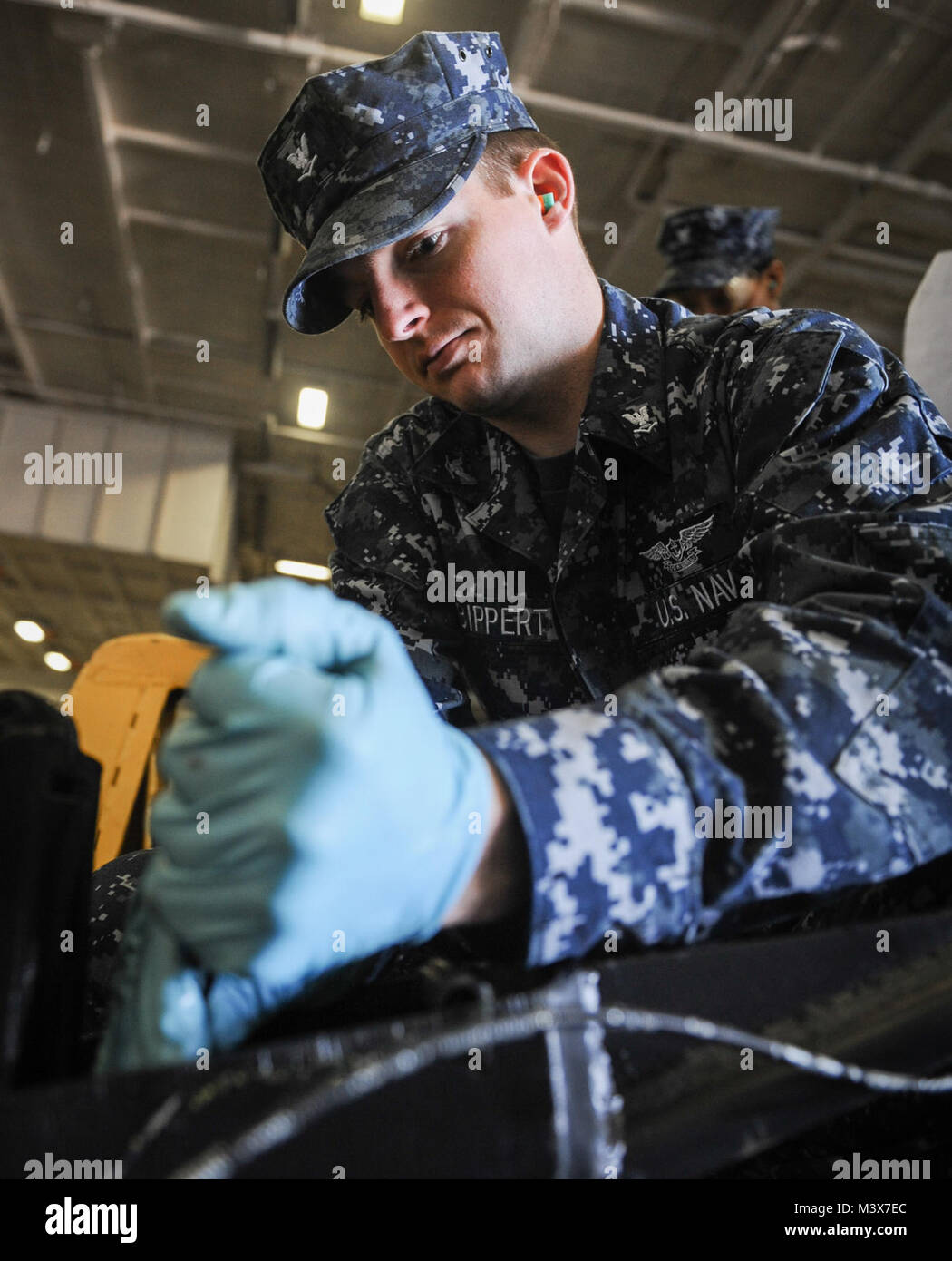EVERETT, Wash. (May 20, 2014)- Aviation Ordnanceman 3rd Class Clinton Bippert, of Castroville, Texas, performs maintenance on a pallet jack in the hangar bay of the aircraft carrier USS Nimitz (CVN 68). Nimitz is currently pierside at its homeport of Naval Station Everett. (U.S. Navy photo by Mass Communication Specialist Seaman Kelly M. Agee/Released) 140520-N-AZ866-035.JPG by USS NIMITZ (CVN 68) Stock Photo