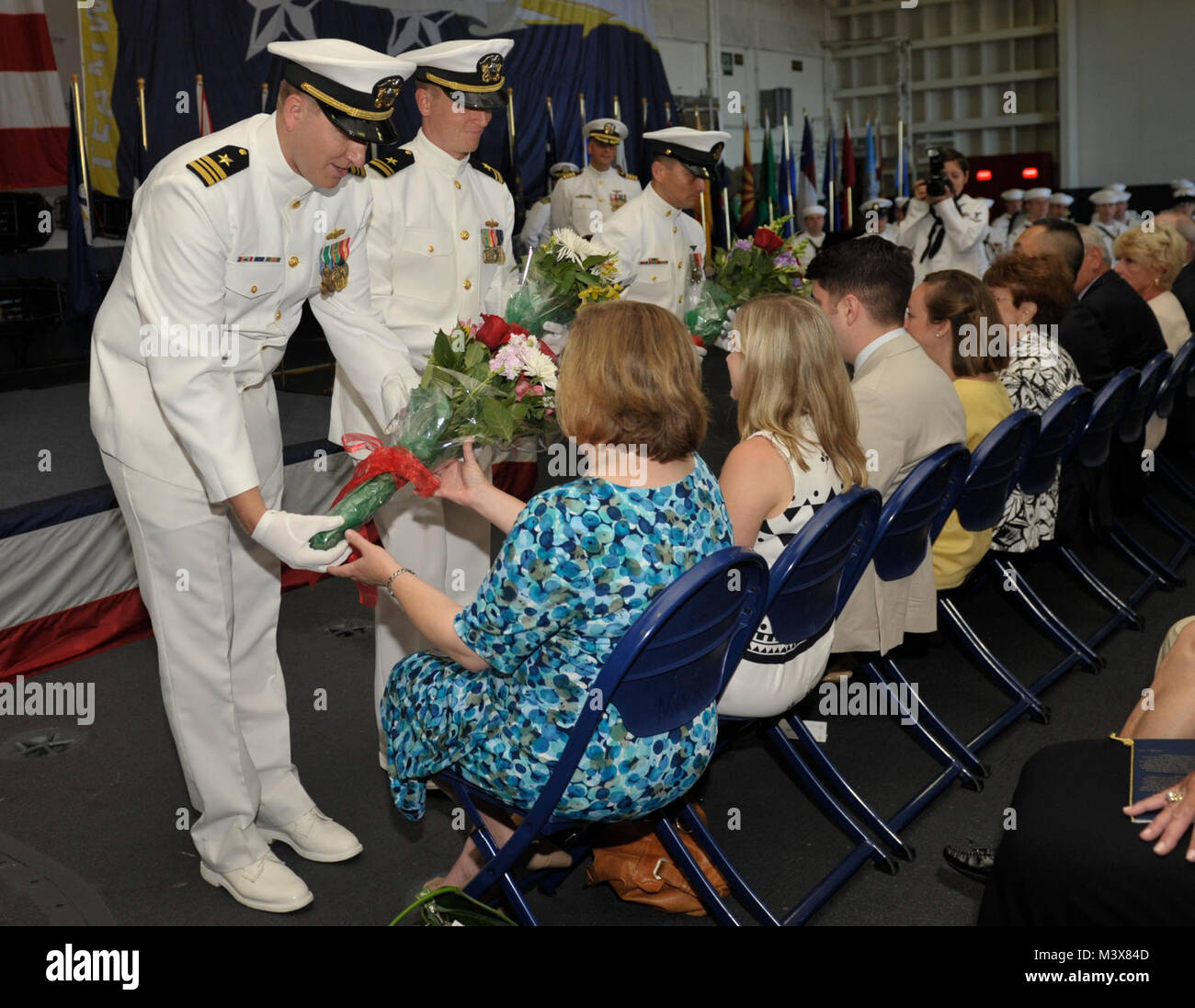EVERETT, Wash. (July 8, 2014) Ceremonial ushers present the family of Rear Adm. Jeff Ruth with flowers during a change of command ceremony for the aircraft carrier USS Nimitz (CVN 68) held in the ship’s hangar bay. During the ceremony, Capt. John Ring assumed command of Nimitz from Ruth. (U.S. Navy photo by Mass Communication Specialist 3rd Class Aiyana S. Paschal/Released) 140708-N-WM477-091.jpg by USS NIMITZ (CVN 68) Stock Photo
