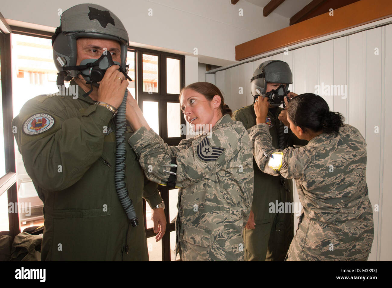 Colombian Air Force Brig. Gen. Carlos Eduardo Bueno and Brig. Gen. Ramses Rueda Rueda (sic) are fitted with flight helmets by U.S. Air Force Tech. Sgt. Hannah Conner and Tech. Sgt. Benita Johnson, both assigned to the 169th Operations Support Squadron's Aircrew Flight Equipment section from McEntire Joint National Guard Base of the South Carolina Air National Guard, Aug. 11, 2014. The fitting is part of the preflight requirements to fly in a SCANG F-16 during Relampago (Lightning) 2014, at Rionegro, Colombia. Relampago is a combined air cooperation engagement with the Republic of Colombia. One Stock Photo