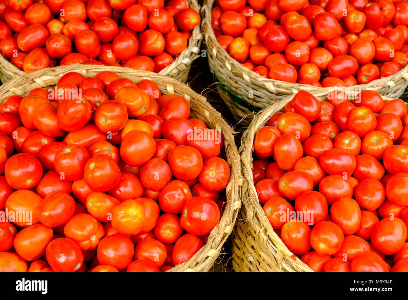 Tomatoes, packed in bamboo baskets, are for sale at the vegetable