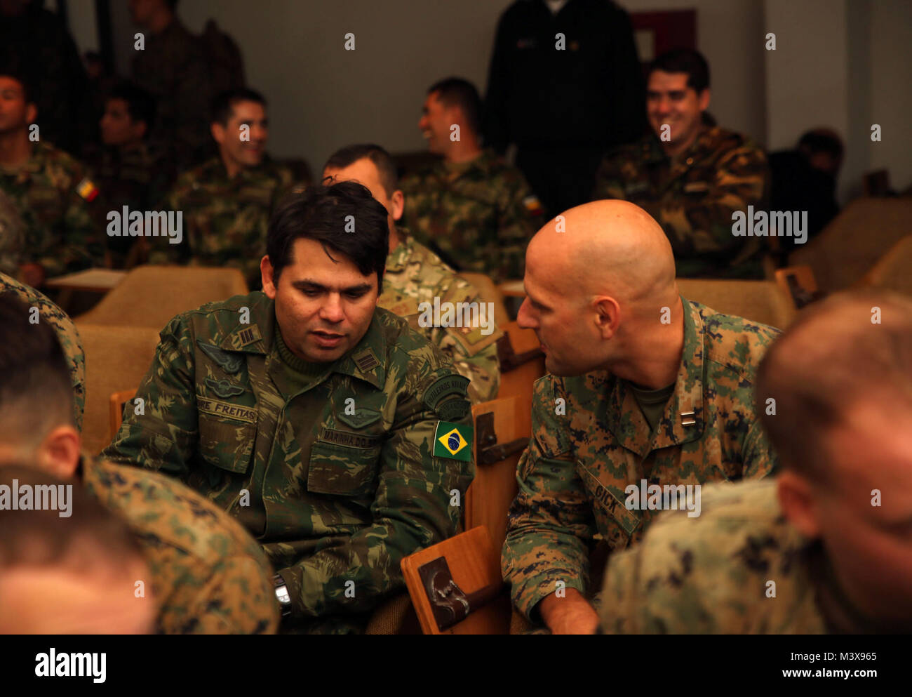 Brazilian Lt. Col. André Freitas, of the amphibious division command, has friendly conversation with U.S. Marine Capt. Timothy Gick, an intelligence officer with 1st Division, 23rd Marines, before they receive a brief explaining the Marine Corps Planning Process given by Expeditionary Warfare Training Group Atlantic at the Chilean Naval Training Center in Valparaiso, Chile, during the Partnership of the Americas exercise August 13, 2014. The training explains the process that the U.S. military follows for amphibious operations, which will be demonstrated in a final exercise. POA 14 is designed Stock Photo