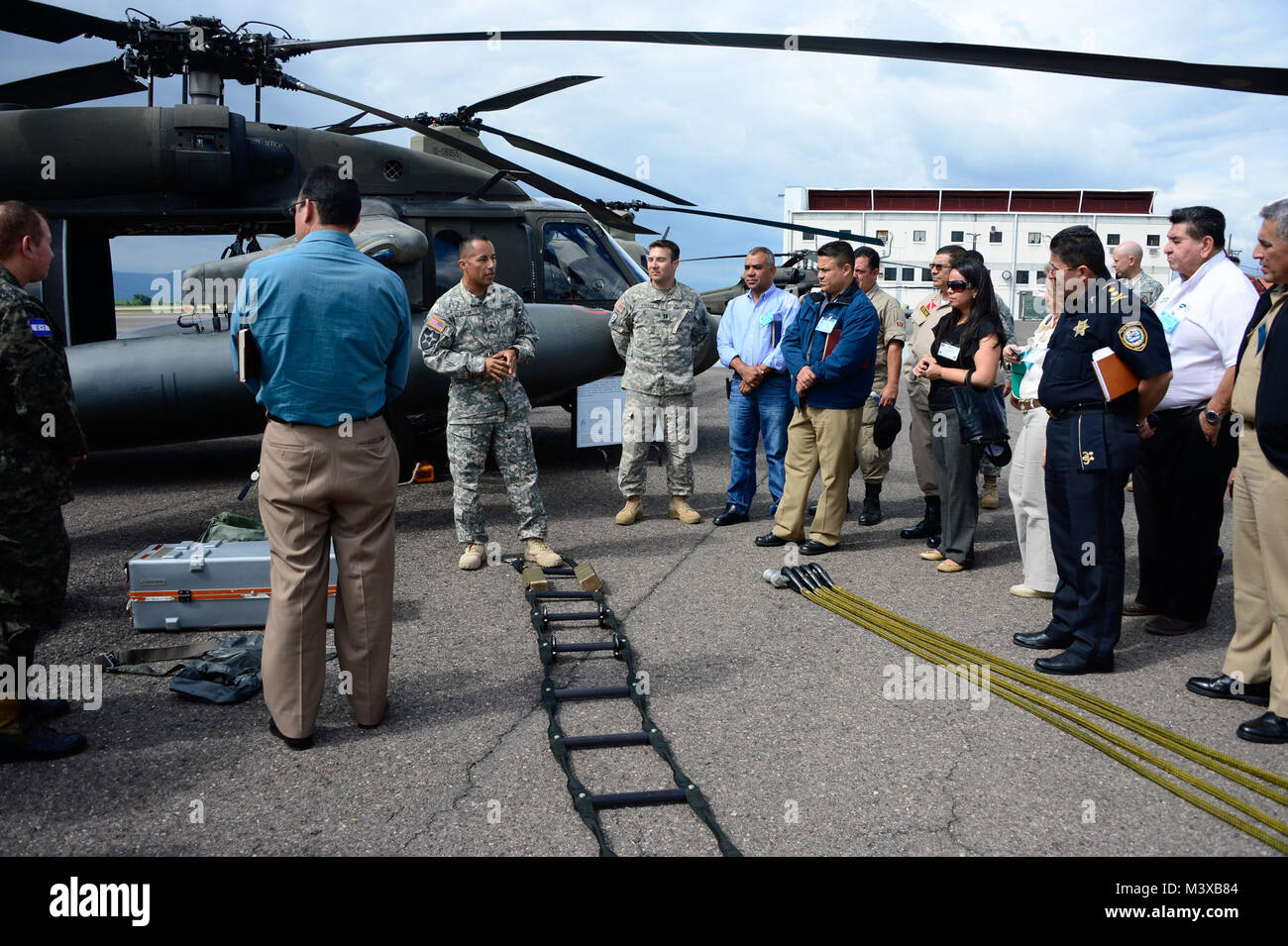 U.S. Army Sgt. Maynor Oliva, crew chief with the 1-228th Aviation Regiment, briefs Joint Task Force-Bravo’s Honduran Leaders’ Day guests on the capabilities of a UH-60L Black Hawk helicopter at Soto Cano Air Base, Honduras, Nov. 14, 2014. Over 40 leaders from around the Republic of Honduras came to learn more about the mission and capabilities of JTF-Bravo and Soto Cano Air Base. (U.S. Air Force photo/Tech. Sgt. Heather Redman) 141114-F-ZT243-178 by ussouthcom Stock Photo
