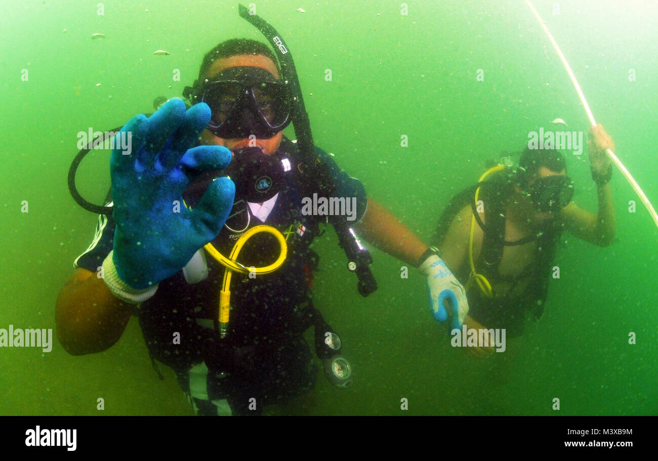 110727-N-XD935-231 PORT ROYAL, Jamaica (July 27, 2011) Jamaican Coast Guard Defense Force Diving Officer Lt. j.g. Christopher YeeSing gives the okay signal during his descent to retrieve an underwater salvage project on the sea floor as part of a joint diving salvage operation with Mobile Diving and Salvage Unit (MDSU) 2. MDSU-2 is participating in Navy Diver-Southern Partnership Station, a multinational partnership engagement designed to increase interoperability and partner nation capacity through diving operations. (U.S. Navy photo by Mass Communication Specialist 1st Class Jayme Pastoric/R Stock Photo