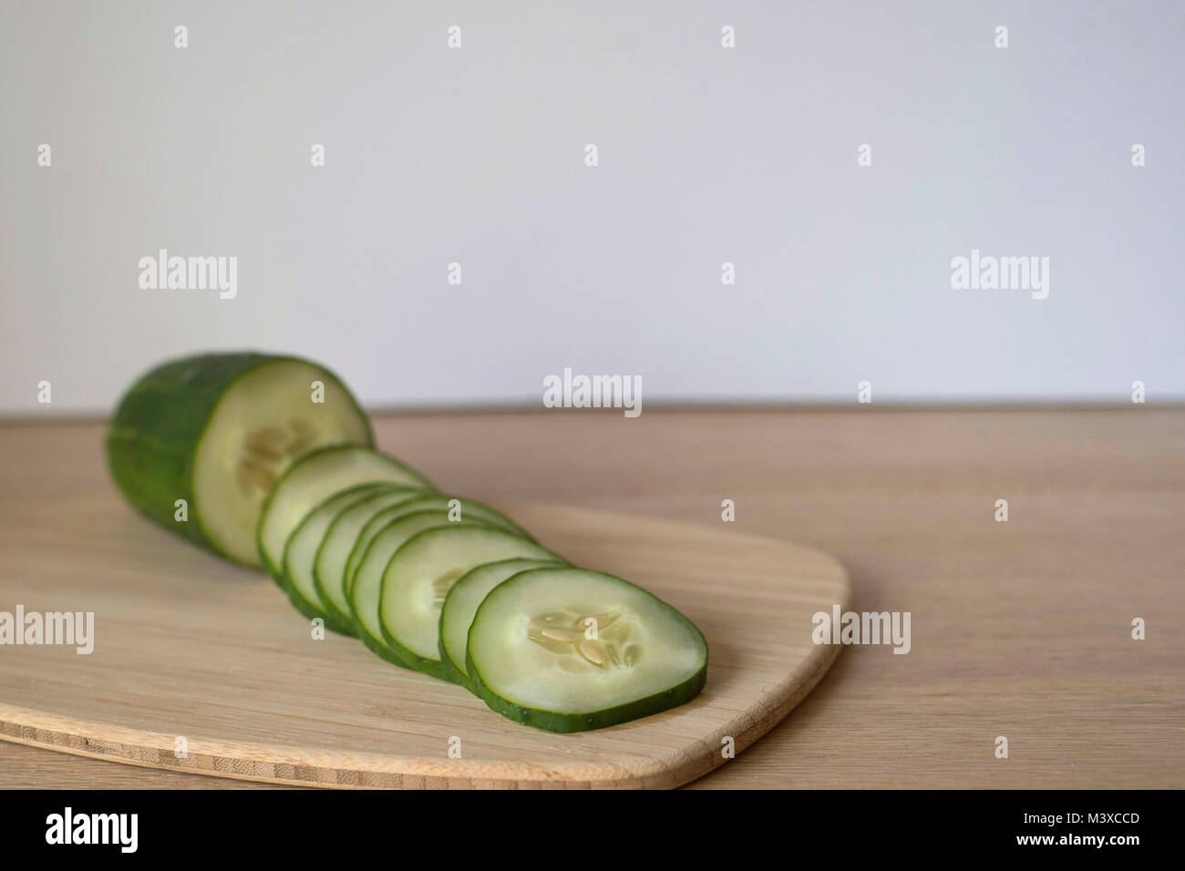 Sliced Cucumbers on a Wood Cutting Board Stock Photo