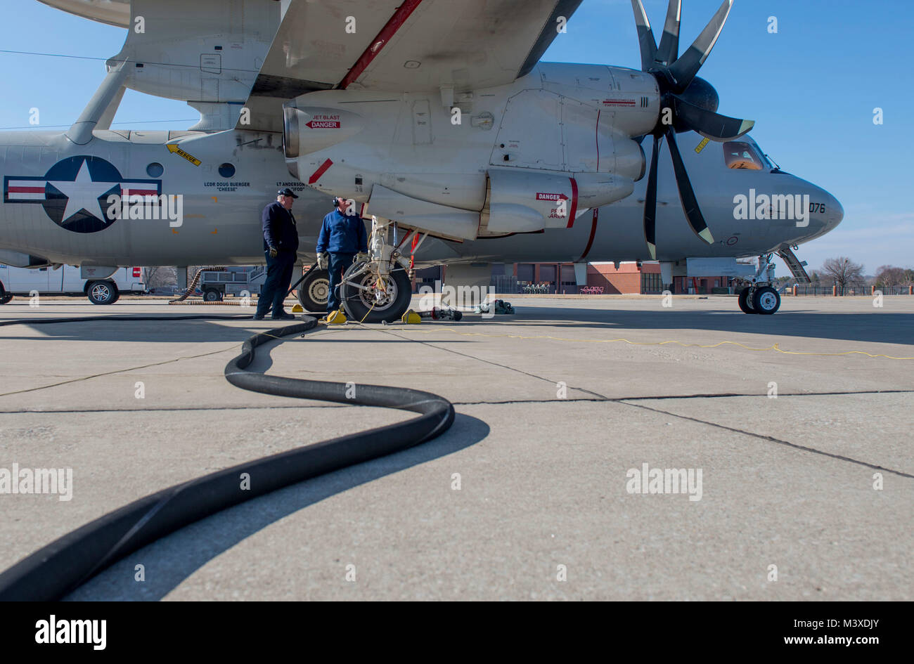 Members of the 375th Operations Support Squadron perform a hot pit refueling on a U.S. Navy E-2D Hawkeye, Jan. 24, 2018, at Scott Air Force Base, Illinois. In a hot pit refueling, the aircraft does not completely shut down, which enables the aircraft to be refueled and take-off quicker, cutting hours off of a coast-to-coast flight. (U.S. Air Force photo by Airman 1st Class Tara Stetler) Stock Photo