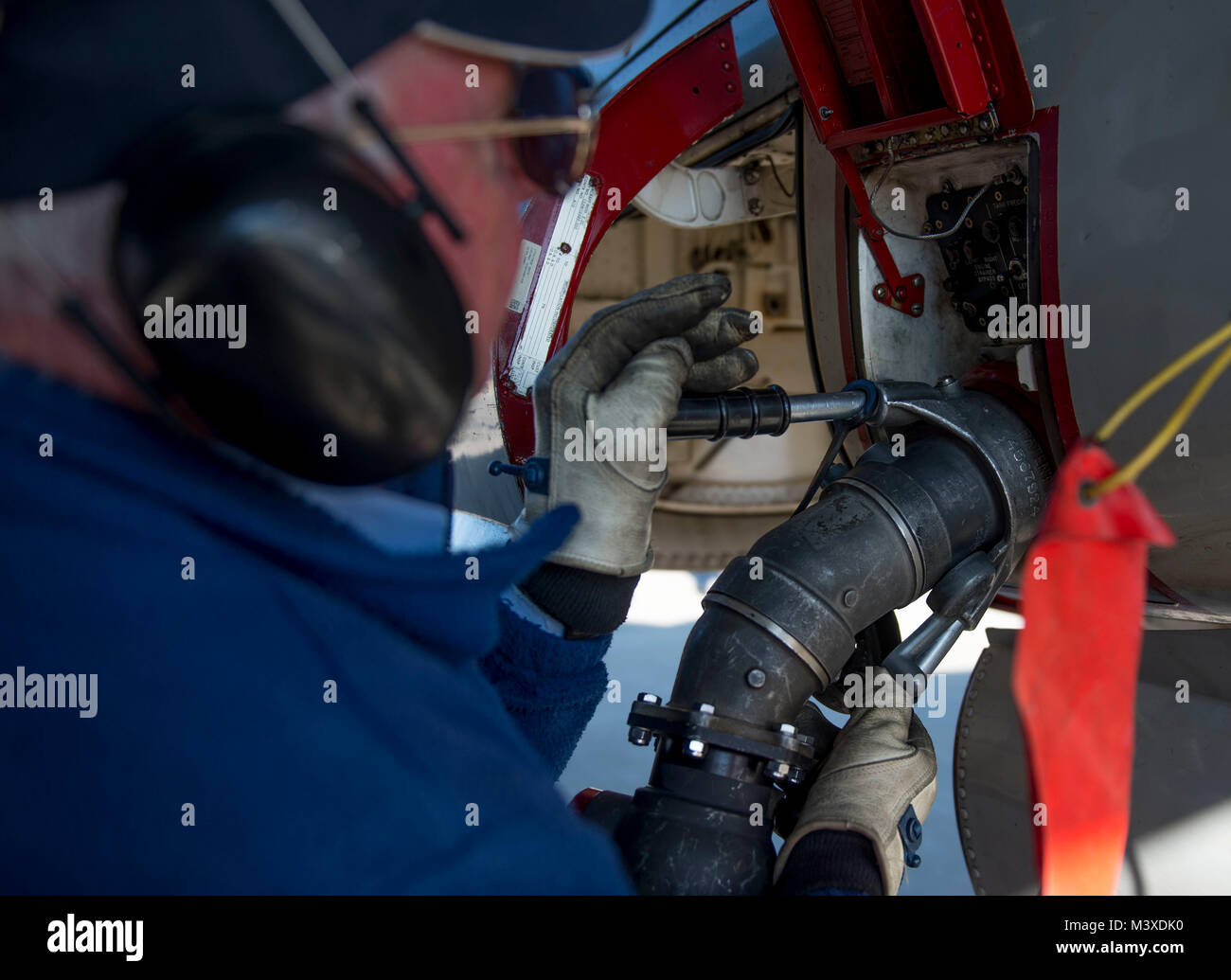 Tom “Scrappy” Oleary, 375th Operations Support Squadron transient alert aircraft servicer, connects a refueling hose to the fuel tank during a U.S. Navy E-2D Hawkeye hot pit refueling, Jan. 24, 2018, at Scott Air Force Base, Illinois. Because of Scott’s central location in the Midwest, it is a convenient spot for aircraft to stop to refuel during coast-to-coast flights. (U.S. Air Force photo by Airman 1st Class Tara Stetler) Stock Photo