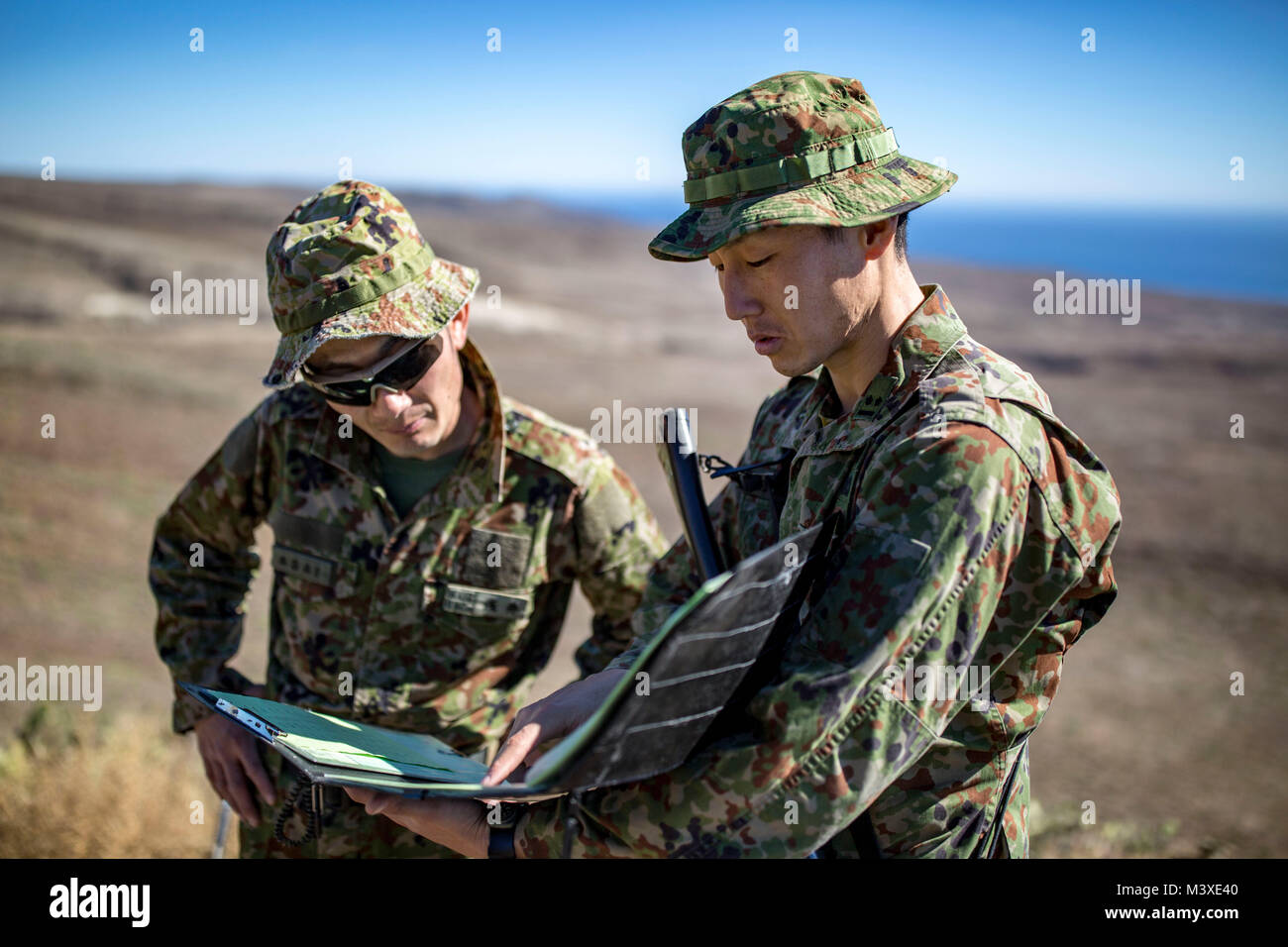 MARINE CORPS BASE CAMP PENDLETON, Calif. – Japan Ground Self Defense Force Soldiers converse about conducting close air support training on San Clemente Island during exercise Iron Fist 2018, Jan. 31. Exercise Iron Fist brings together U.S. Marines from the 11th Marine Expeditionary Unit and soldiers from the JGSDF, Western Army Infantry Regiment, to improve their bilateral planning, communicating, and conducting of combined amphibious operations. (U.S. Marine Corps photo by Cpl. Jacob A. Farbo) Stock Photo