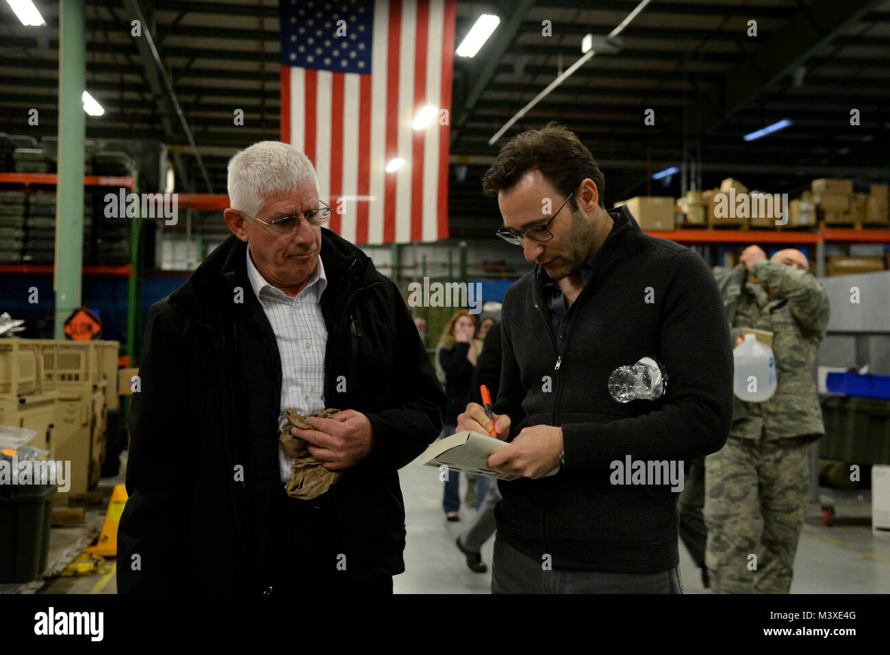 Simon Sinek signs a book for James Pacer, 436th Airlift Wing Transition Assistance Program manager, after a briefing with Team Dover customer service Airmen Feb. 1, 2018, at Dover Air Force Base, Del. Sinek explained the significance of good leadership and how it relates to the customer service experience. (U.S. Air Force photo by Staff Sgt. Aaron J. Jenne) Stock Photo