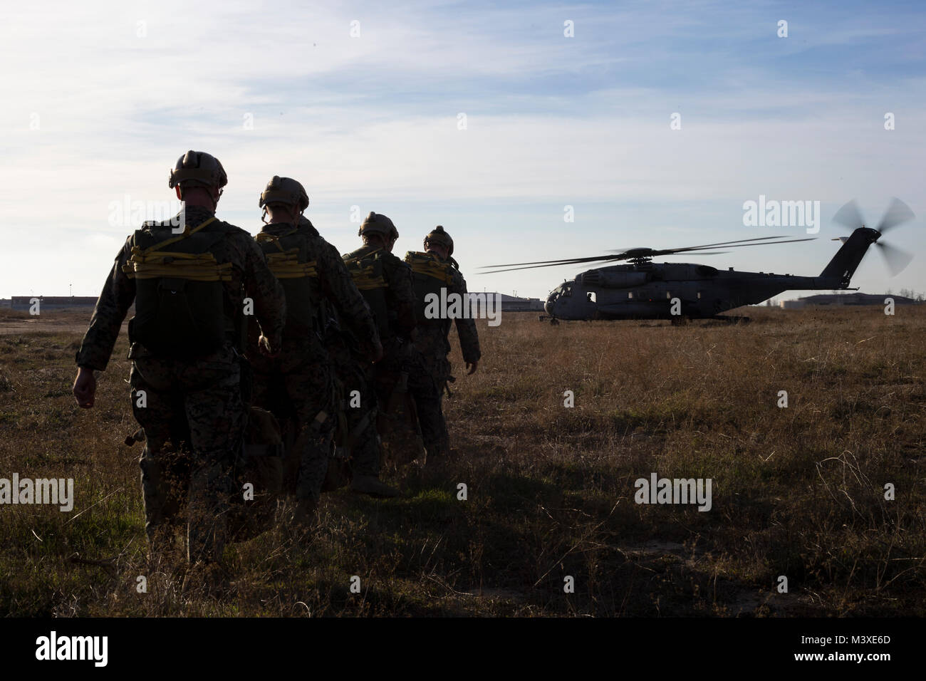 U.S. Marines with 1st Reconnaissance Battalion, 1st Marine Division, walk towards a CH-53E Super Stallion helicopter before a Low Level Static Line (LLSL) parachute exercise at Marine Corps Base Camp Pendleton, Calif., Feb. 1, 2018. LLSL parachute operations are conducted to increase proficiency with the MC-6 parachute system. (U.S. Marine Corps photo by Cpl. Robert G. Gavaldon) Stock Photo