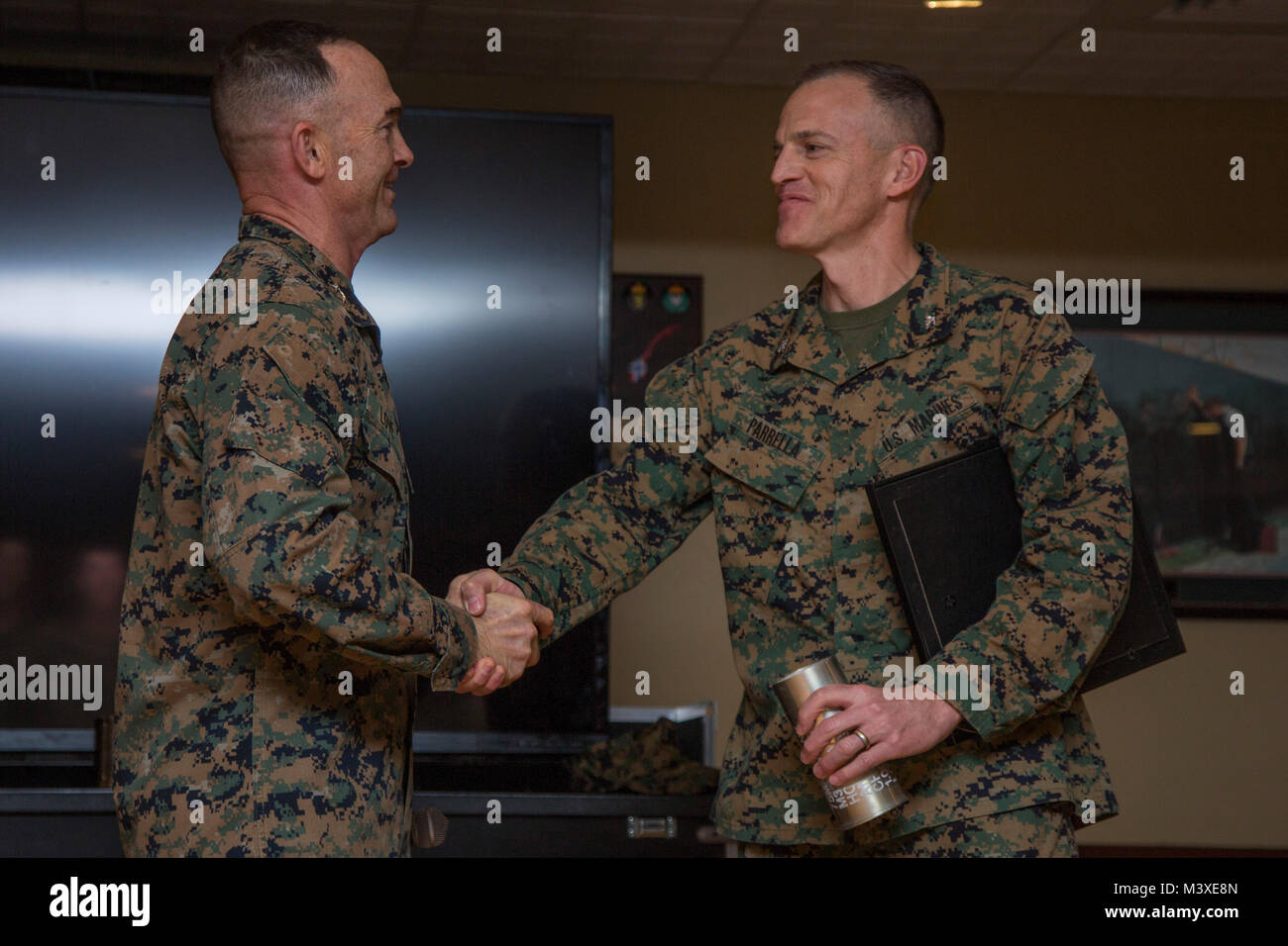 U.S. Marine Corps Maj. Gen. John K. Love, commanding general, 2nd Marine Division (2d MARDIV), left, and Col. Keith A. Parrella shake hands on Camp Lejeune, N.C., Feb. 2, 2018. Parrella was awarded for being the first to complete the 2d MARDIV 50-mile challenge hike, with a time of 7 hours and 30 minutes. (U.S. Marine Corps photo by Lance Cpl. Taylor N. Cooper) Stock Photo