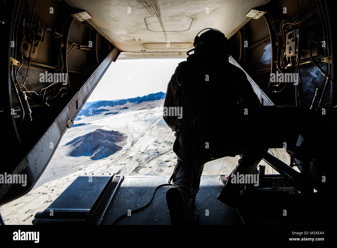 A Marine with Marine Wing Support Squadron 371 scans the skies in an MV-22 Osprey at Marine Corps Air Ground Combat Center, Twentynine Palms, Calif., Feb. 4, 2018, as a part of Integrated Training Exercise 2-18. The purpose of ITX is to create a challenging, realistic training environment that produces combat-ready forces capable of operating as an integrated MAGTF. (U.S. Marine Corps Photo by Pfc. William Chockey) Stock Photo