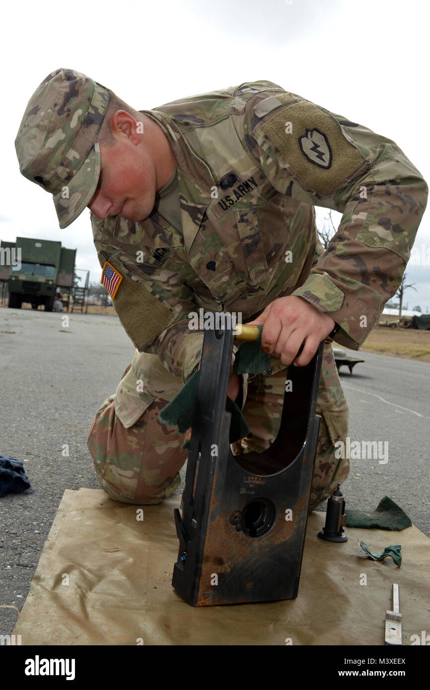 Spc. Brandon McKim, a cannon crewmember assigned to Battery B, 2nd Battalion, 11th Field Artillery Regiment, 25th Division Artillery, 25th Infantry Division, cleans the breach of a M119A3 howitzer at Fort Polk, Louisiana, on Feb. 6, 2018. Soldiers assigned to the 25th Infantry Division are participating in an annual rotation at the Joint Readiness Training Center. (U.S. Army photo by Staff Sgt. Armando R. Limon, 3rd Brigade Combat Team, 25th Infantry Division) Stock Photo