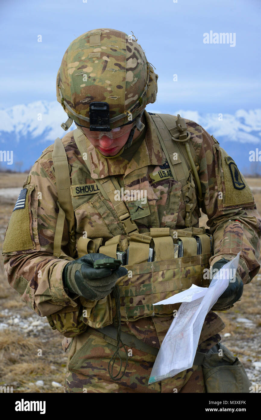 A U.S. Army Paratrooper assigned to the 1st Battalion, 503rd Infantry Regiment, 173rd Airborne Brigade maintain their land navigation skills during the weeklong testing for the Expert Infantryman Badge. The soldiers must complete a number of prerequisites and pass a battery of graded tests on basic Infantry skills Feb. 6, 2018 at Cellina Meduna area, Pordenone, Italy. (U.S. Army Photo by Paolo Bovo) Stock Photo