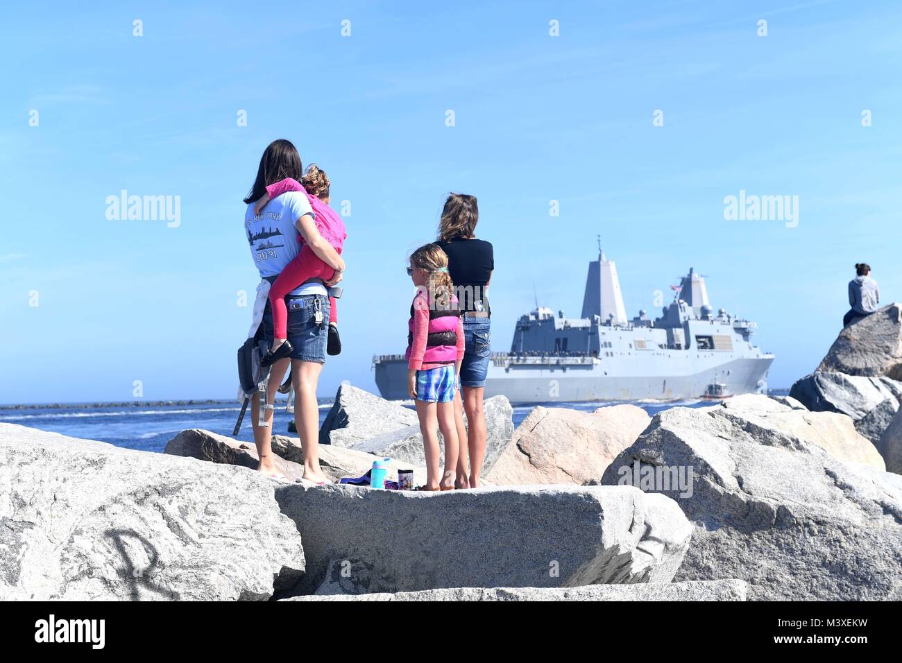 180207-N-JX484-090 JACKSONVILLE, Fla. (Feb. 7, 2018) Family members observe as the amphibious transport dock ship USS New York (LPD 21) departs Naval Station Mayport for a scheduled six-month deployment. The New York is deploying as part of the Iwo Jima Amphibious Assault Ready Group and with the 26th Marine Expeditionary Unit to conduct maritime security operations, crisis response and theater security cooperation, while also providing a forward naval presence in Europe and the Middle East. (U.S. Navy photo by Petty Officer 2nd Class Mark Andrew Hays/Released) Stock Photo