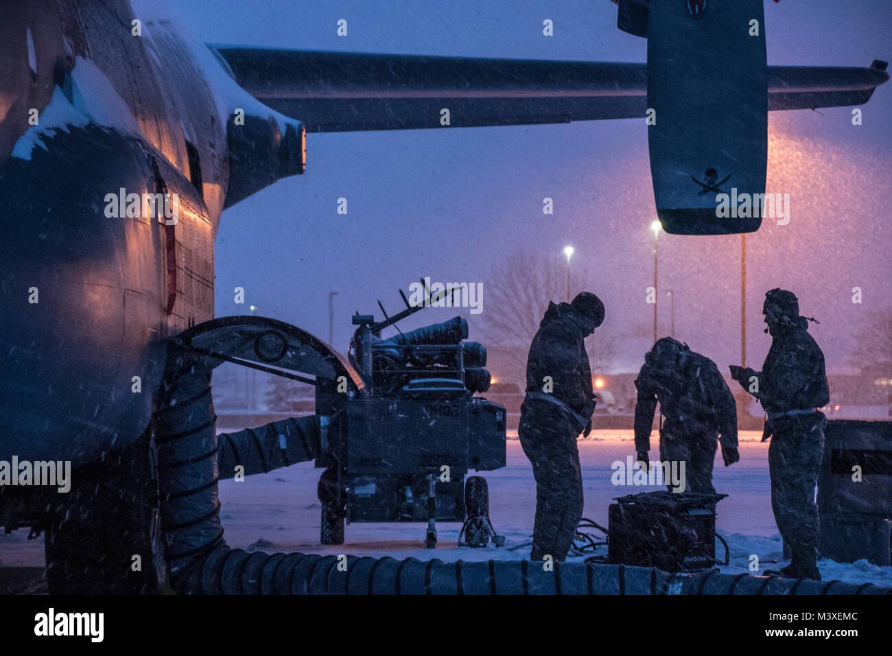 Airmen work on the brake systems of a C-130H Hercules during a snow storm, Feb. 07, 2018, at the 179th Airlift Wing, Mansfield, Ohio. The 179th Airlift Wing maintenance group regularly inspects all aspects of their aircraft to maintain mission readiness with ready airmen and ready aircraft. (U.S. Air National Guard photo by Tech. Sgt. Joe HarwoodReleased) Stock Photo