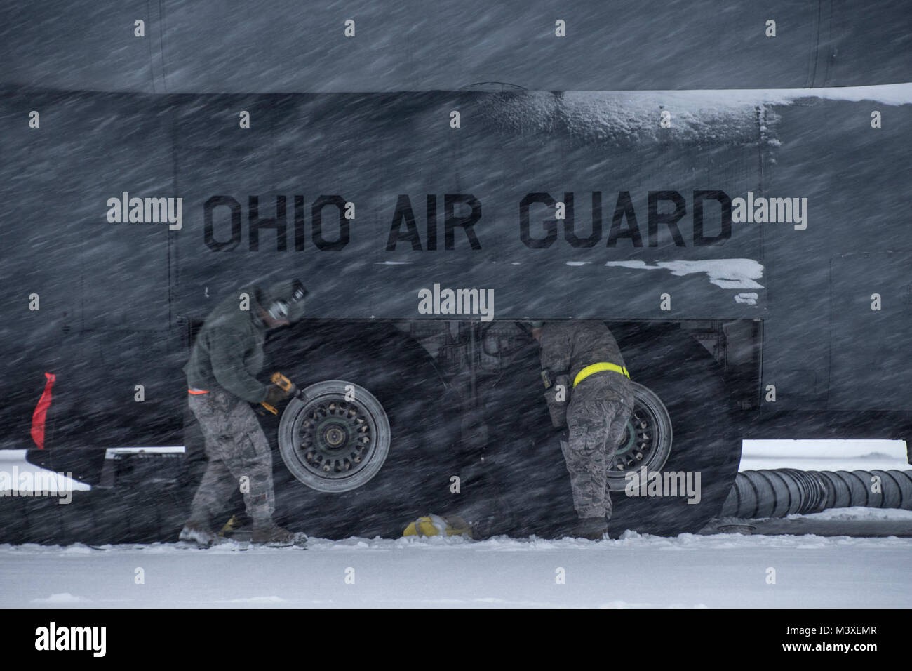Airmen work on the brake systems of a C-130H Hercules during a snow storm, Feb. 07, 2018, at the 179th Airlift Wing, Mansfield, Ohio. The 179th Airlift Wing maintenance group regularly inspects all aspects of their aircraft to maintain mission readiness with ready airmen and ready aircraft. (U.S. Air National Guard photo by Tech. Sgt. Joe HarwoodReleased) Stock Photo