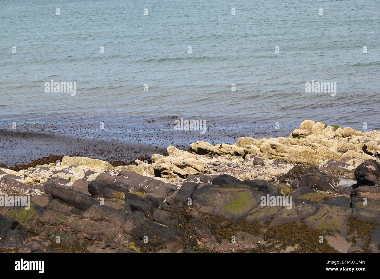 Peel Bay, Peel, Isle of Man. Clean water. Seaweed on rocks and in the