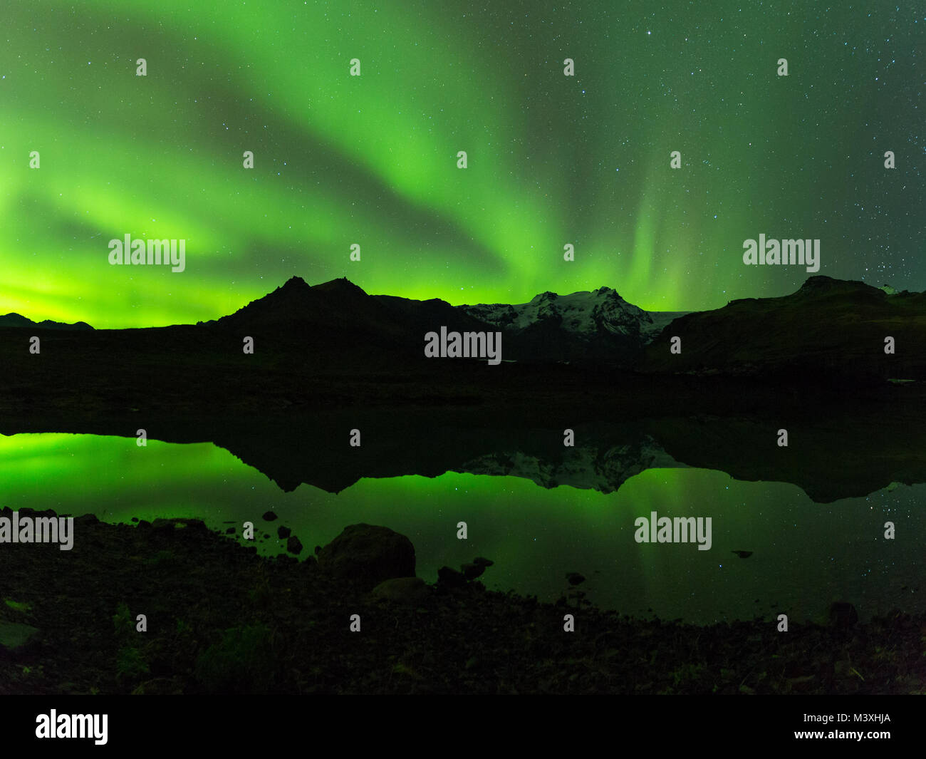 Green aurora light behind Lake mountain in iceland europe at national park skaftafell Stock Photo