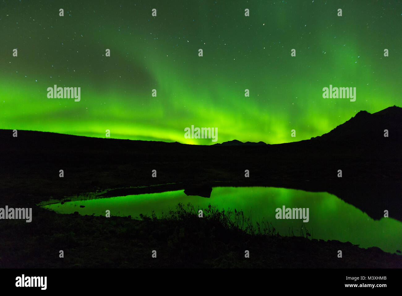 Green aurora light behind Lake mountain in iceland europe at national park skaftafell Stock Photo