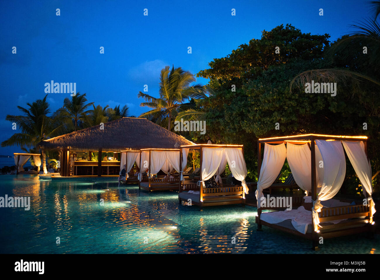 Swimming pool and restaurant in The Residence Hotel and Resort, Gaafu Alifu Atoll. Maldives Islands. Stock Photo