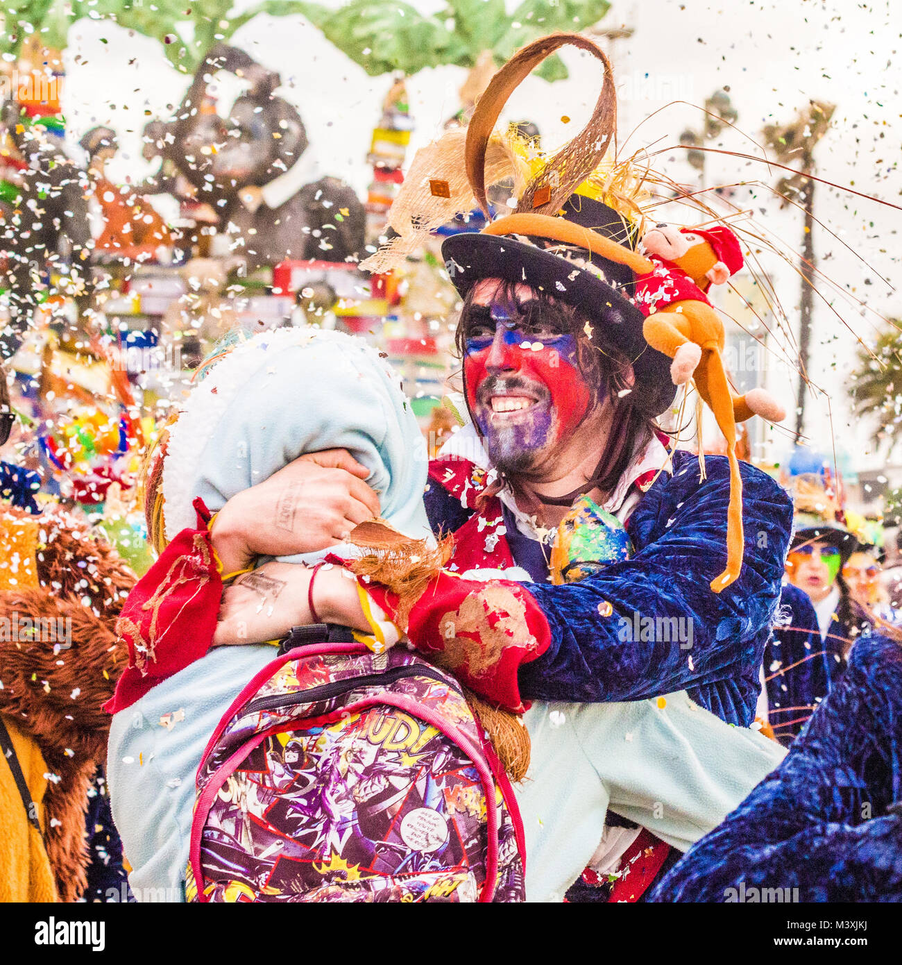 Happy moment as friends embrace during the Viareggio Carnival in the Lucca province of Tuscany, Italy. Stock Photo