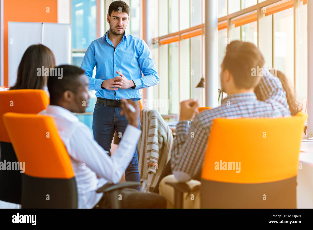 Group of casually dressed businesspeople discussing ideas in the office. Stock Photo