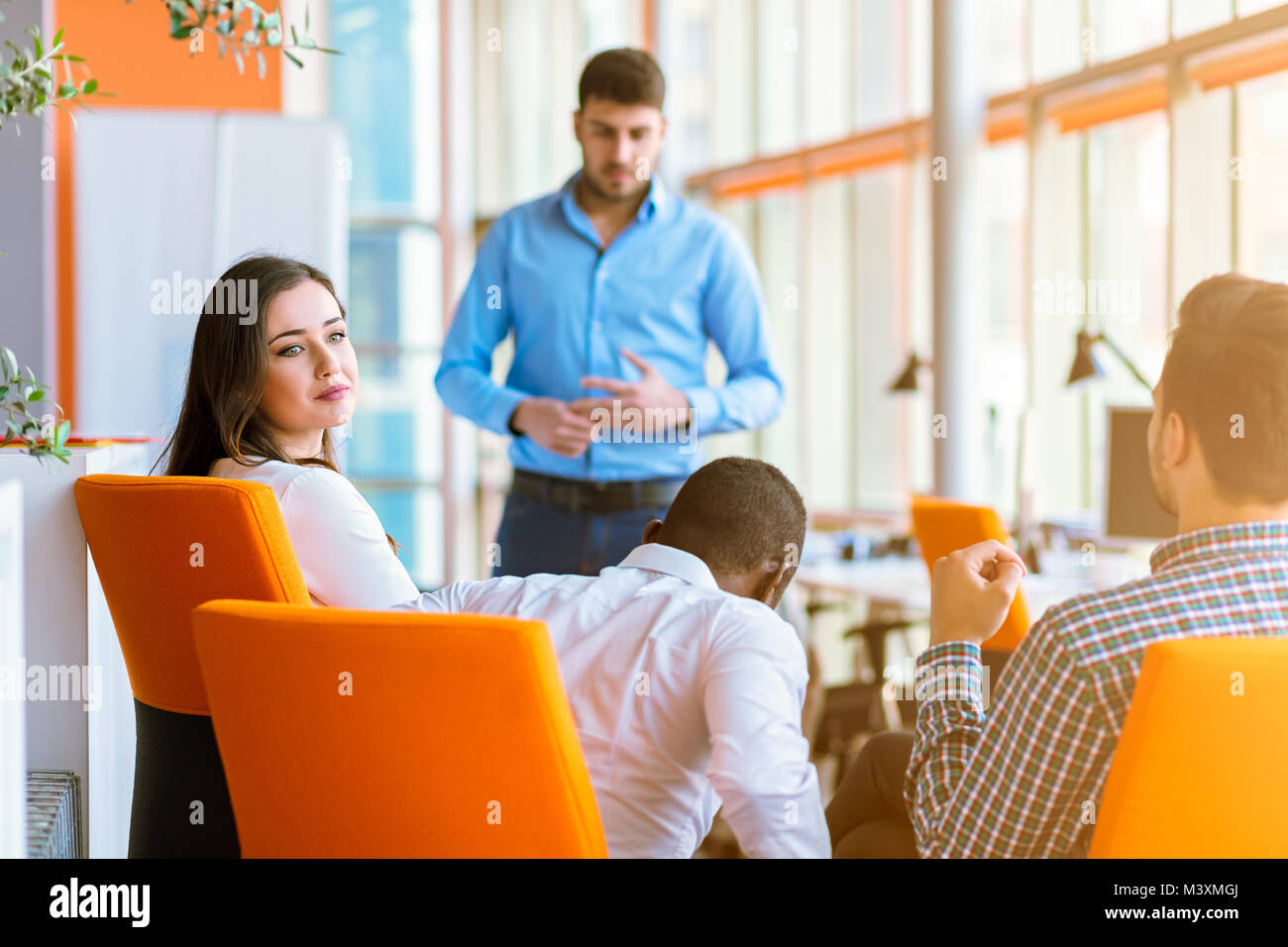 Group of casually dressed businesspeople discussing ideas in the office. Stock Photo