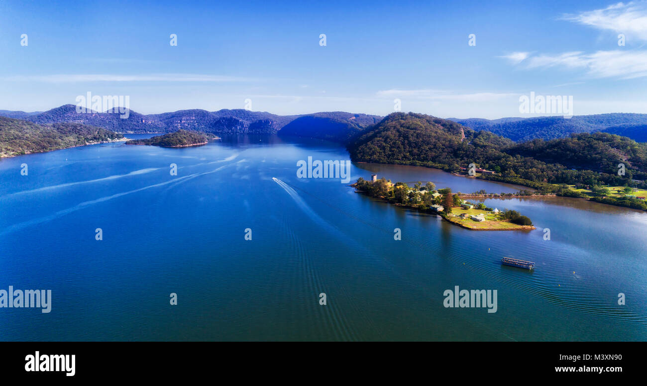 Mighty wide Hawkesbury river near Mooney Mooney fishing town on Motorway 1 M1 of Greater Sydney surrounded by foresty hills under blue sky. Stock Photo