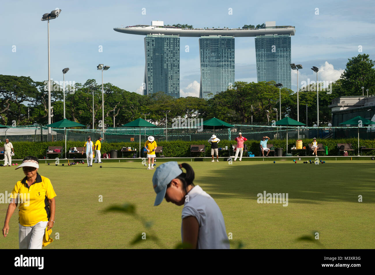 04.11.2017, Singapore, Republic of Singapore, Asia - People are lawn bowling next to the Singapore Cricket Club with the Marina Bay Sands Hotel. Stock Photo